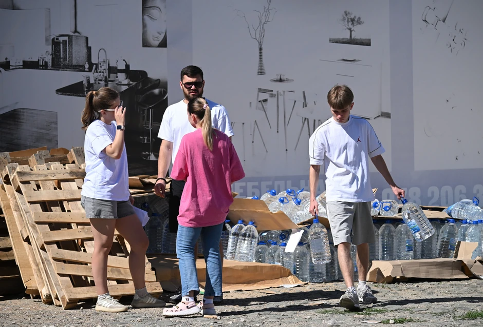 Lokalni stanovnik nosi flaše sa vodom za piće iz humanitarne pomoći koju su dopremili volonteri u Džankoju na Krimu