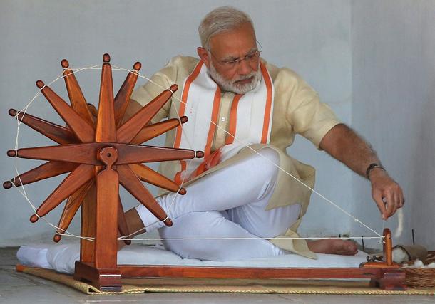 India's PM Modi spins cotton on a wheel during his visit to Gandhi Ashram in Ahmedabad