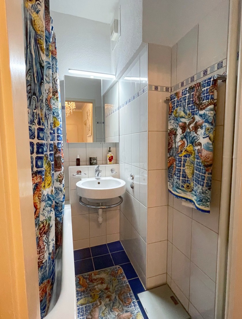 Le rideau de douche, le tapis de bain et la serviette sont coordonnés. 