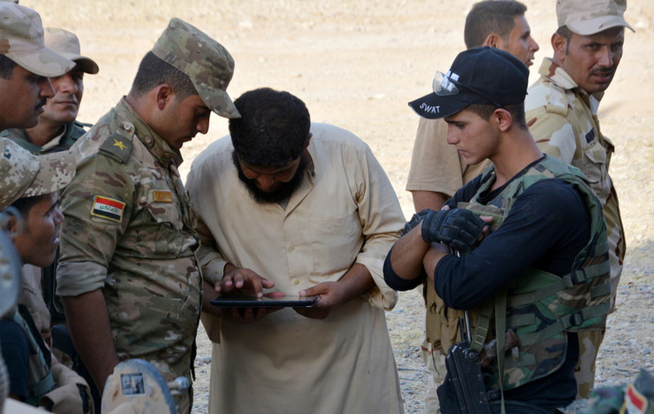 A displaced man from south of Mosul gives the coordinates of Islamic State militants to Iraqi soldiers south of Mosul.