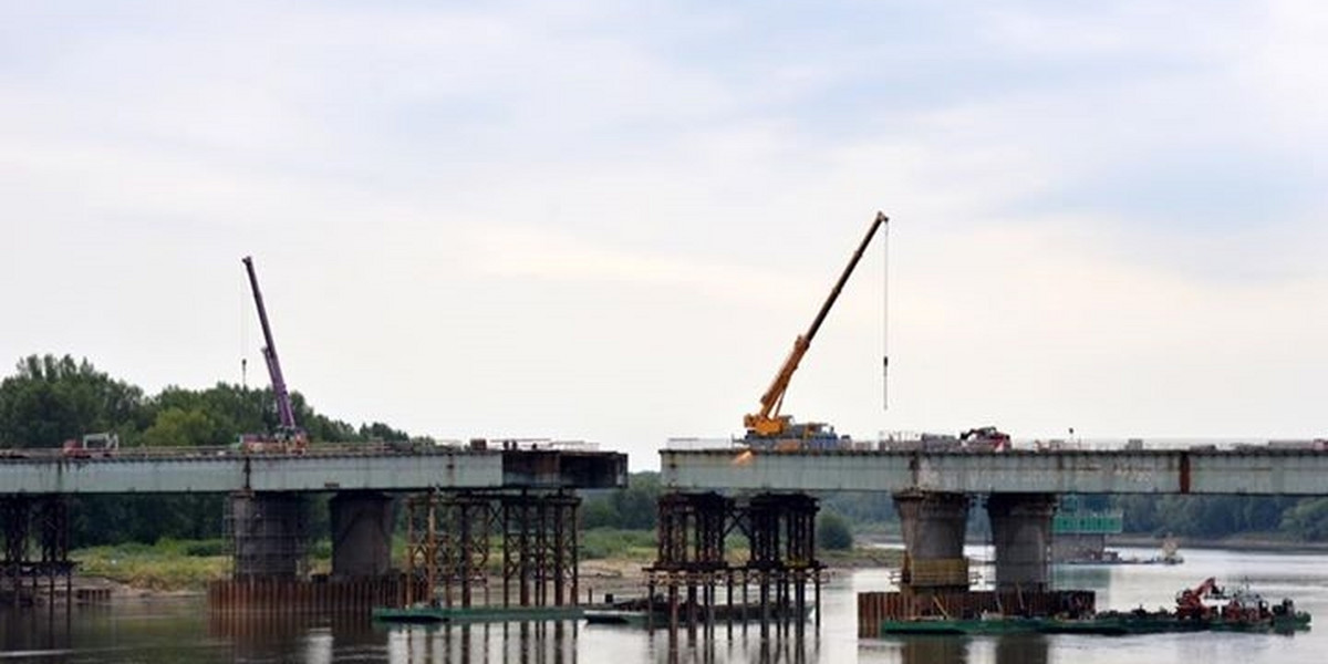 Robotnicy nasuwają kolejna czesc mostu Łazienkowskiego