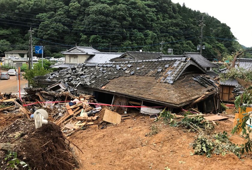 A car is pictured after it was drifted by torrential rain in Hitoyoshi