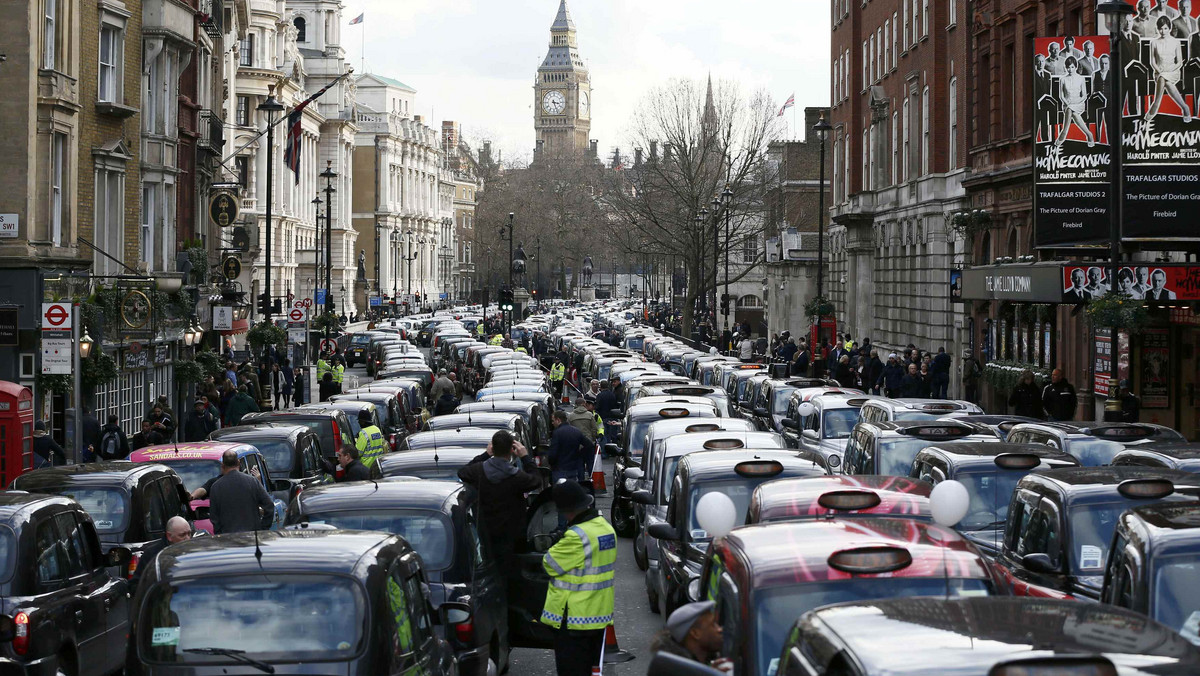A police officer stands between rows of taxis during a protest by London cab drivers against Uber in central London