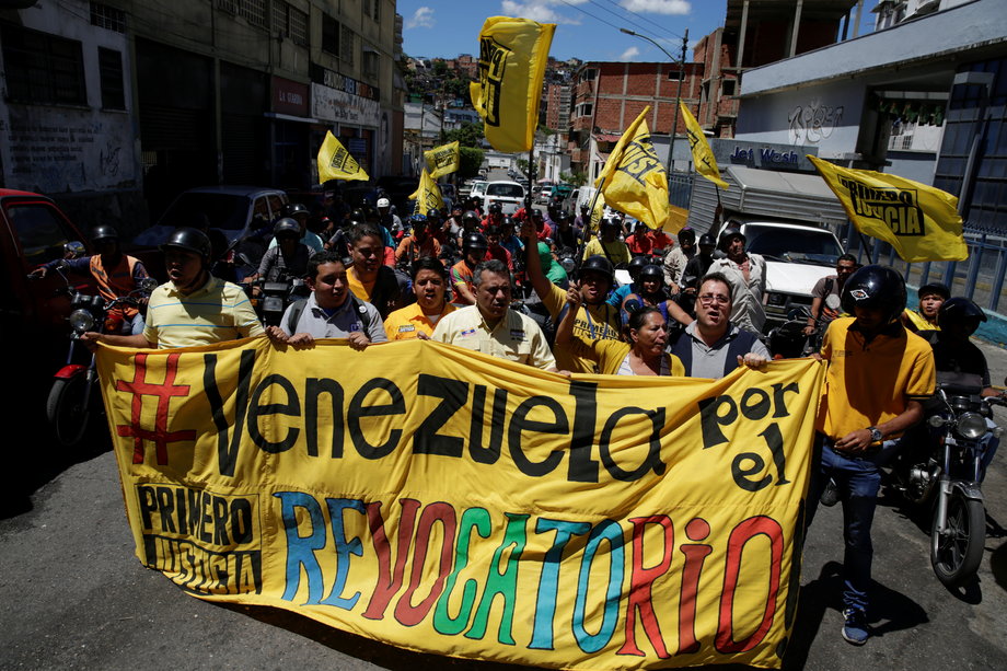 Opposition supporters shout slogans as they take part in a rally to demand a referendum to remove Venezuela's President Nicolas Maduro in Caracas, Venezuela, August 4, 2016. The banner reads "Venezuela for the recall."