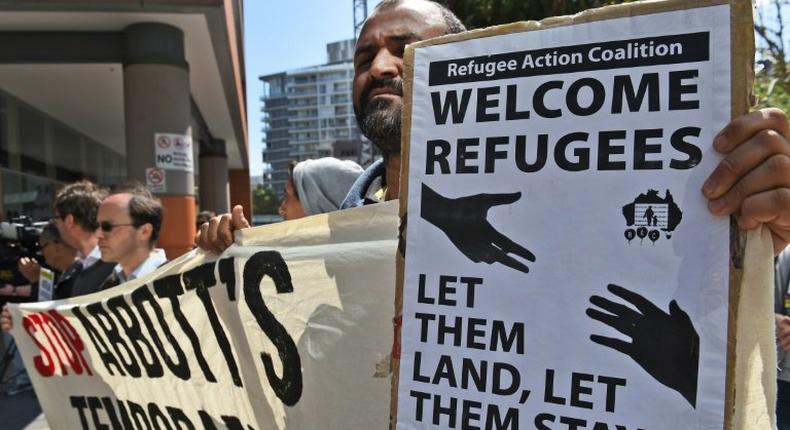 A protester holds up a placard opposing Australia's refugee policy