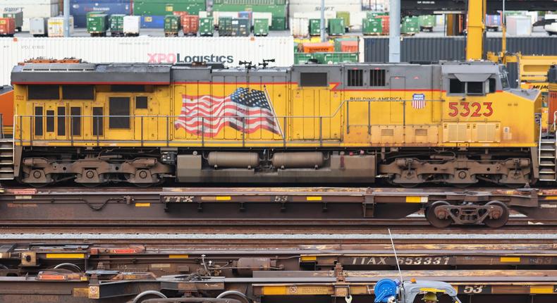 A worker driving near freight trains and shipping containers in a Union Pacific Intermodal Terminal rail yard on November 21 in Los Angeles.Mario Tama/Getty Images