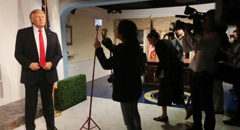 Members of the media attend the unveiling of the new wax figurine of President-elect Donald Trump (L) at Madame TussaudÕs wax museum in Washington, DC.