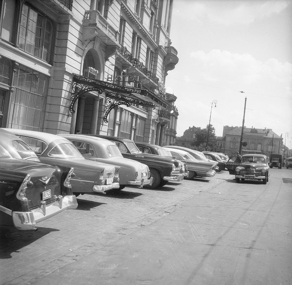 Parking przed hotelem w latach 50. XX w. i obecnie. Źródło: NAC
