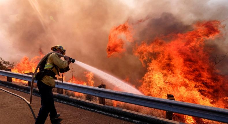 A firefighter battles a fire along the Ronald Reagan Freeway, also known as state Highway 118, in Simi Valley, California in 2018.
