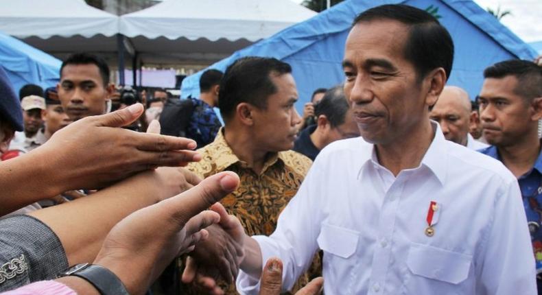 Indonesian President Joko Widodo shakes hands with quake survivors at a temporary shelter in Pidie Jaya, Aceh province