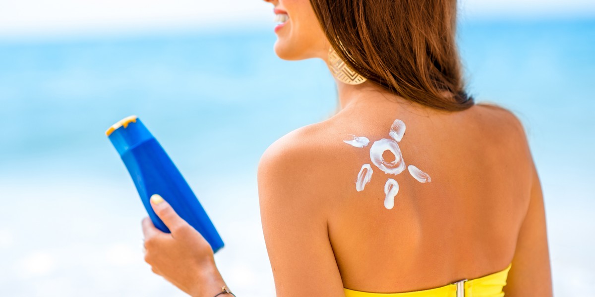 Woman using sun cream on the beach