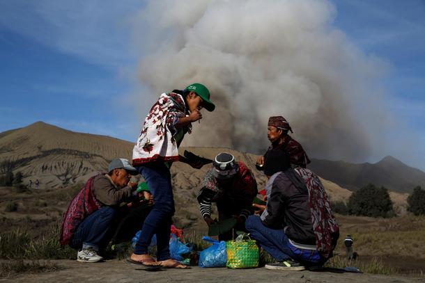 Mount Bromo spews ash as Hindu villagers take their breakfast ahead for Kasada ceremony, when villag