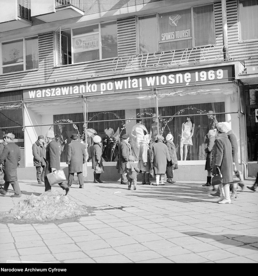 Przechodnie przed sklepem "Paulinka". Widoczny szyld "warszawianko powitaj wiosnę 1969"