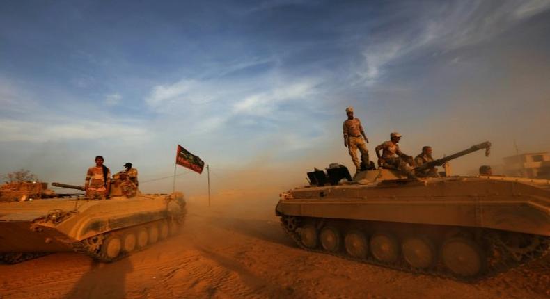 Iraqi forces stand on their BMP-1 vehicles in Jarif, 45km south of Mosul