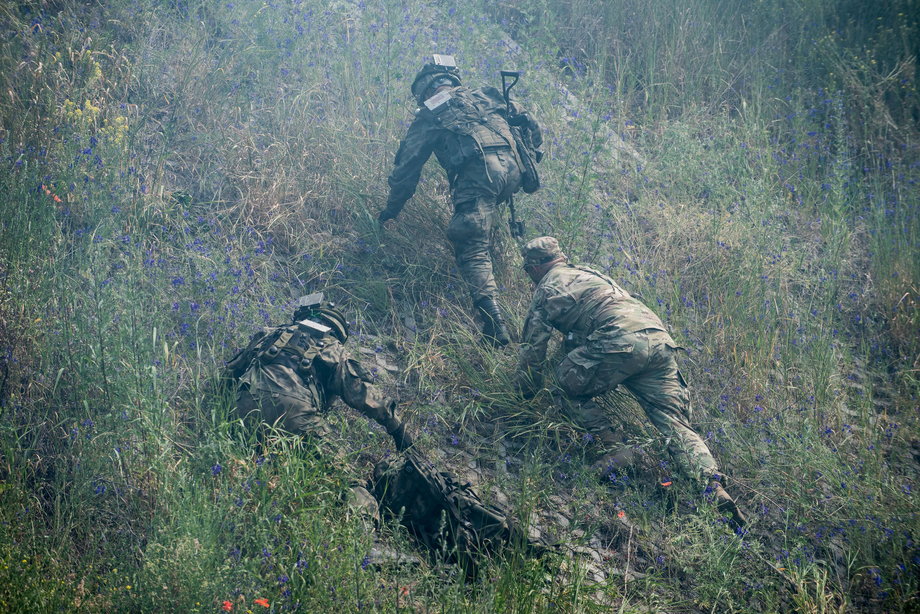 Żołnierze wspinają się na skarpę w pobliżu mostu w Toruniu.