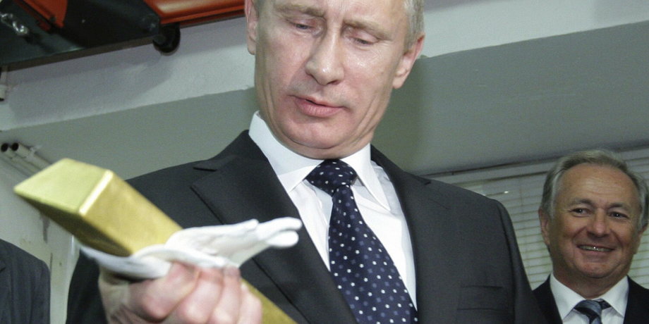 Władimir Putin trzyma sztabkę złota podczas wizyty w Centralnym Depozycie Banku Rosji w styczniu 2011 r., gdy był premierem.