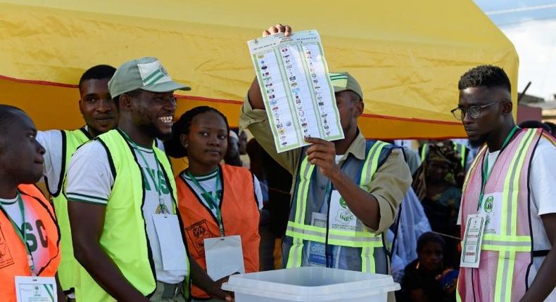 An electoral officer raises a ballot to count results after the Osun State gubernatorial election, which will go to a runoff in what is seen as a litmus test for President Buhari's popularity as he seeks a second term in February