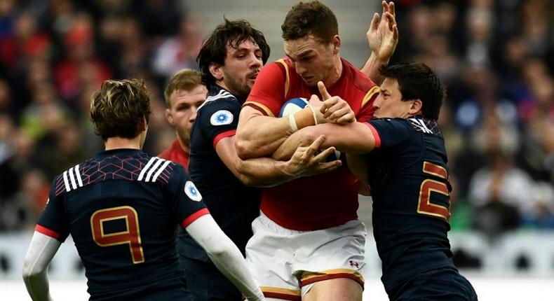 Wales' wing George North (C) is tackled during a Six Nations match against Wales at the Stade de France in Saint-Denis, outside Paris, on March 18, 2017
