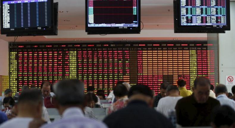 Investors look at computer screens in front of an electronic board showing stock information at a brokerage house in Shanghai, China, July 14, 2015.  REUTERS/Aly Song