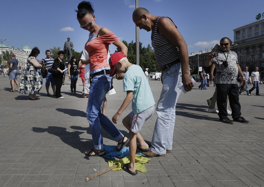 Roditelji pokazuju sinu kako treba postupati s ukrajinskom zastavom