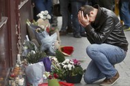 A man pays his respect outside the Le Carillon restaurant the morning after a series of deadly attacks in Paris