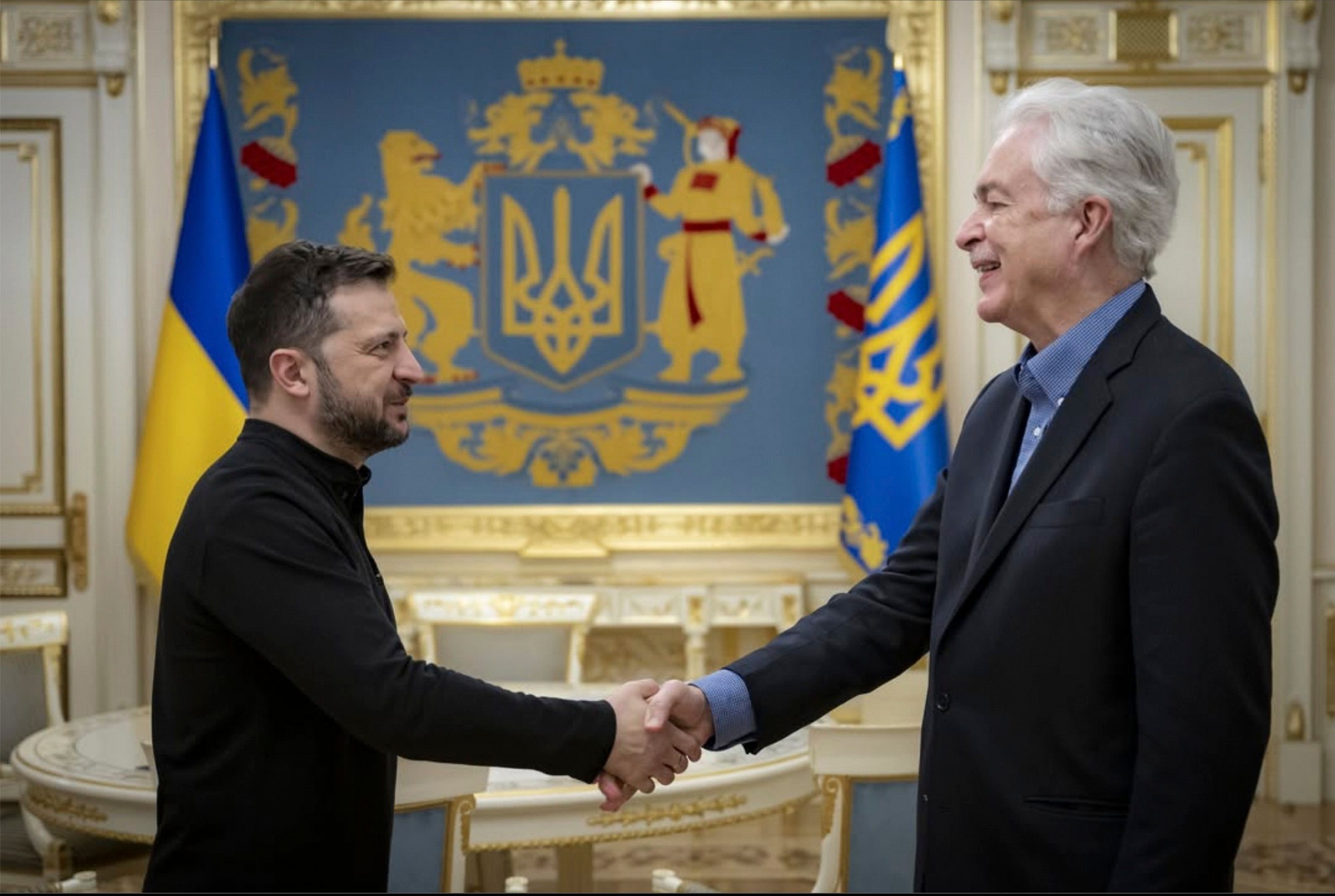 Ukrainian President Volodymyr Zelenskyi (left) shakes hands with CIA Director William Burns.