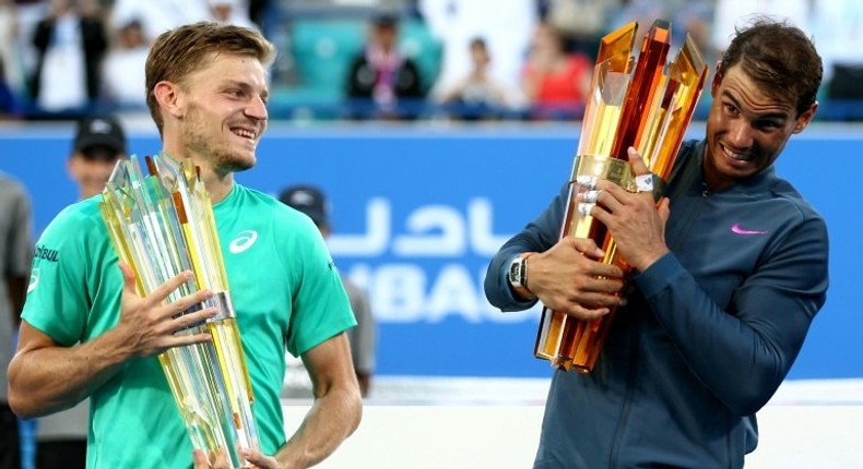 Spain's Rafael Nadal (R) poses with the winner's trophy with Belgium's David Goffin after the final of the Mubadala World Tennis Championship 2016 in Abu Dhabi on December 31, 2016. Nadal won 6-4, 7-6.