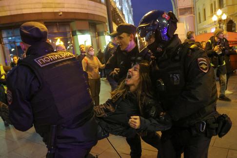 Rosyjscy policjanci zatrzymują dziewczynę protestującą przeciwko mobilizacji rezerwistów, Moskwa, 21 września 2022 r.