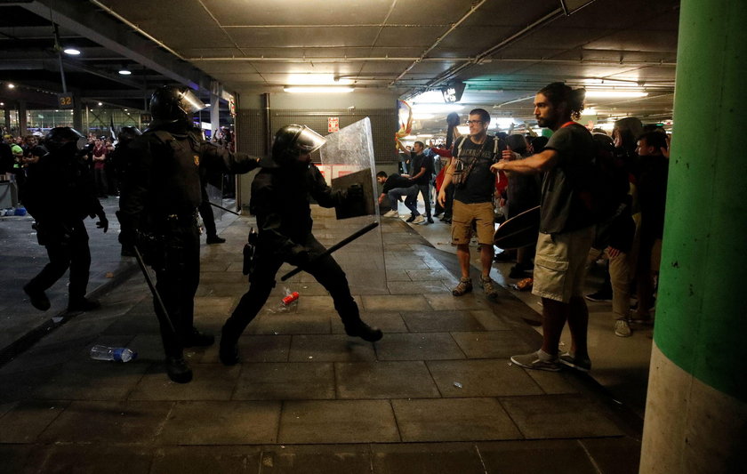 Passengers look as a police officer walks past at Barcelona's airport, during a protest after a verd