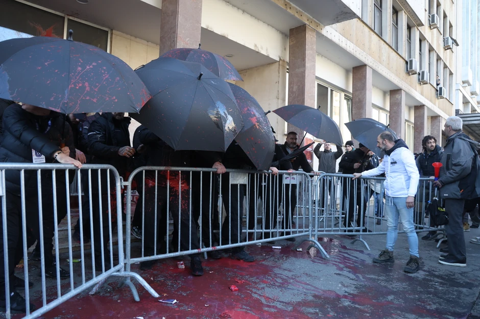 Obezbeđenje otvorilo kišobrane kada su okupljeni počeli da bacaju farbu