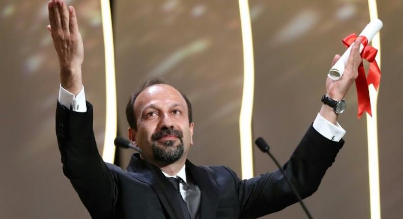 Iranian director Asghar Farhadi celebrates after being awarded the Best Screenplay prize for the film The Salesman at the 69th Cannes Film Festival in Cannes, southern France on May 22, 2016