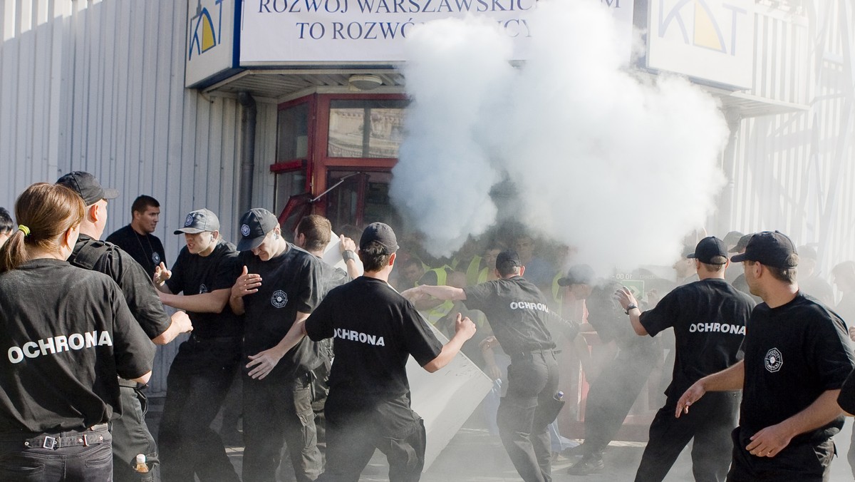 Ochroniarze w maskach przeciwgazowych rozpylają gaz łzawiący i próbują wejść do środka Kupieckich Domów Towarowych w Warszawie. Rozpoczęło się od założenia masek przeciwgazowych. Kupcy próbowali się przedrzeć przez kordon. Ze środka trwa kontratak kupców broniących się za pomocą gaśnic.