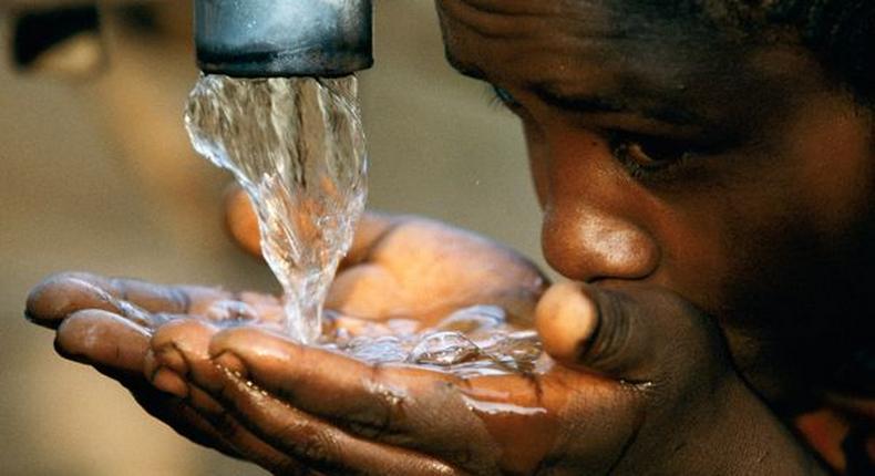  A girl drinking water from a faucet