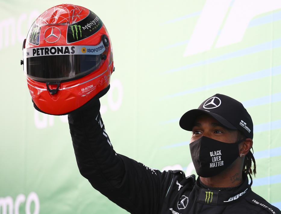 Lewis Hamilton Michael Schumacher egyik sisakjával, amikor utolérte a 91. futamgyőzelemmel. / Fotó: EPA/Bryn Lennon