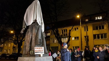 Protest pod pomnikiem ks. Jankowskiego. Prześcieradło na głowie duchownego i głośne dzwony z kościoła