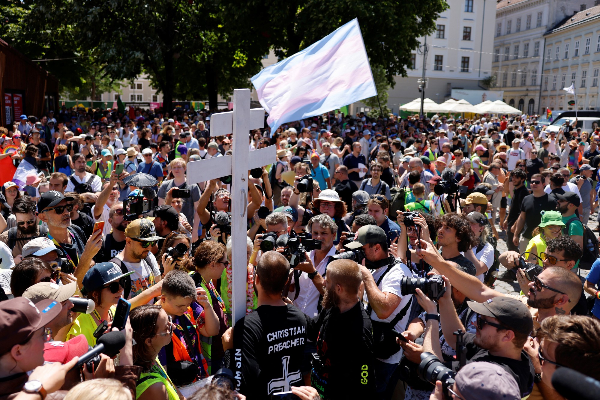Muž protestuje proti pochodu Pride v Budapešti v mikine s náboženským motívom, ktorý vyzýva na "Odvrátenie od hriechu."