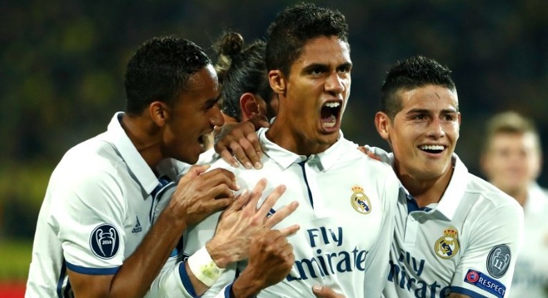 Real Madrid's French defender Raphael Varane (C) celebrates with teammates after scoring a goal during their UEFA Champions League Group F match against Borussia Dortmund, at BVB stadium in Dortmund, on September 27, 2016