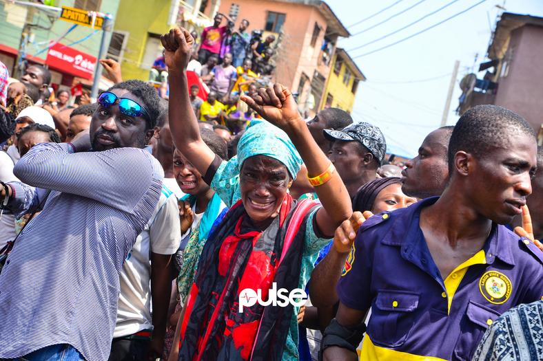 Tears of joy, a woman lifts her hands in the air as she watches a child being rescued (Pulse) 