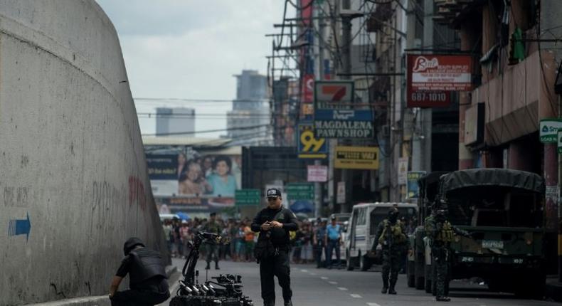 Bomb squad operatives and a bomb disposal robot inspect a suspicious package in Quiapo, Manila on May 7, 2017