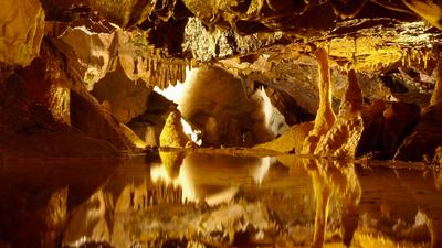 Stalactites and stalagmites reflected in pool, Gough's Cave, Cheddar Caves, Somerset, England, UK