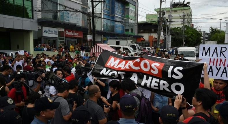 Anti-Marcos protesters (R) face off with pro-Marcos supporters (L) waving miniature national flags while the late dictator Ferdinand Marcos was being given a hero's burial in Manila on November 18, 2016