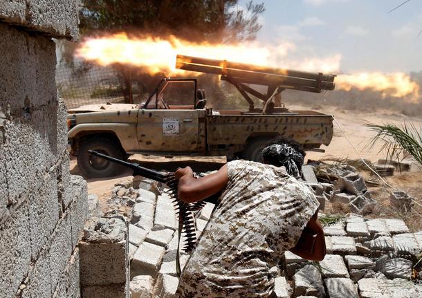 Libyan forces allied with the U.N.-backed government fire weapons during a battle with IS fighters i