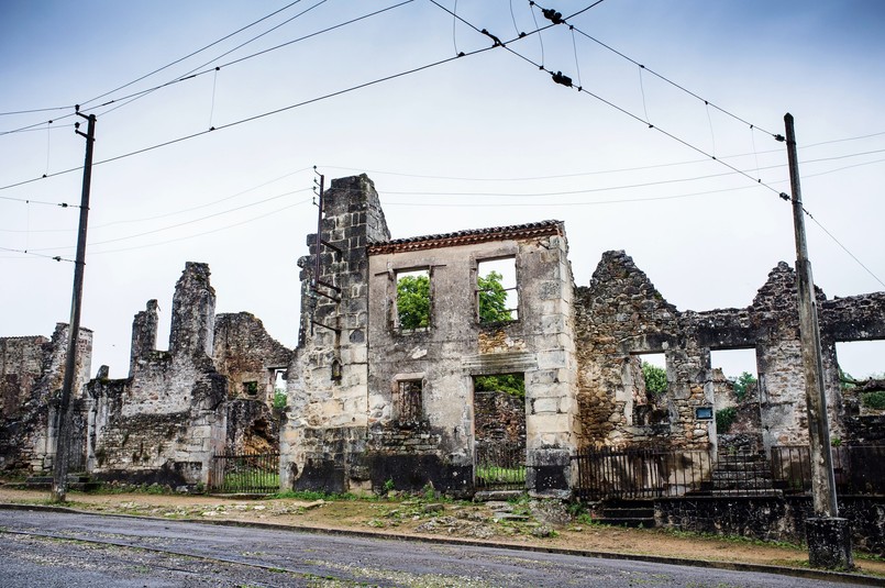 Tragedia rozegrała się 10 czerwca 1944 roku. Oddziały SS w odwecie za zabicie przez francuski ruch oporu oficera SS weszły do miasteczka, wyganiając mieszkańców z domów i rozstrzeliwując wszystkich bez wyjątku - mężczyzn, kobiety i dzieci. Tych, którzy nie zginęli od razu, Niemcy zapędzili do kościoła. Budynek podpalili, wrzucali do środka granaty, strzelali do osób, które próbowały uciec. Tego dnia wymordowali 642 mieszkańców miasteczka. Przeżyła 47-letnia kobieta, której udało się wyskoczyć przez okienko w kościele i uciec, pięciu mężczyzn oraz jedno dziecko. Jak się potem okazało, Niemcy wymierzyli tę okrutną karę mieszkańcom nie tego miasta, które planowali spacyfikować. W rzeczywistości oficer SS został zabity w Oradour-sur-Vayres. Miasteczka nigdy nie odbudowano. Jego ruiny zamieniono po wojnie w ogromne muzeum. Wizyta w tym miejscu robi duże wrażenie. Na ulicach i podwórkach wciąż stoją auta zabitych mieszkańców, gdzieniegdzie pod ścianą domu widać oparty zardzewiały rower, można również zobaczyć część osobistych przedmiotów ofiar. Oradour-sur-Glane to jedna z czterech miejscowości, jakie w czasie wojny spotkał taki los. W podobny sposób, mordując mieszkańców w zemście, Niemcy potraktowali również Lidice w Czechach, Mazinote we Włoszech oraz wieś Sochy na Lubelszczyźnie. Tragedię tej ostatniej opisała Anna Janko w książce "Mała Zagłada" (CZYTAJ WIĘCEJ NA TEN TEMAT >>>)