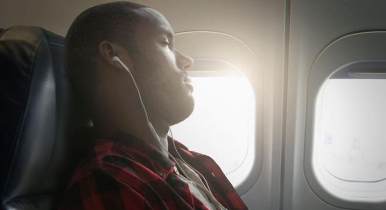 Black man sleeping on a plane [Getty/Jose Luis Pelaez]