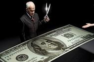 Businessman holding scissors and reaching hands around one hundred dollar bill