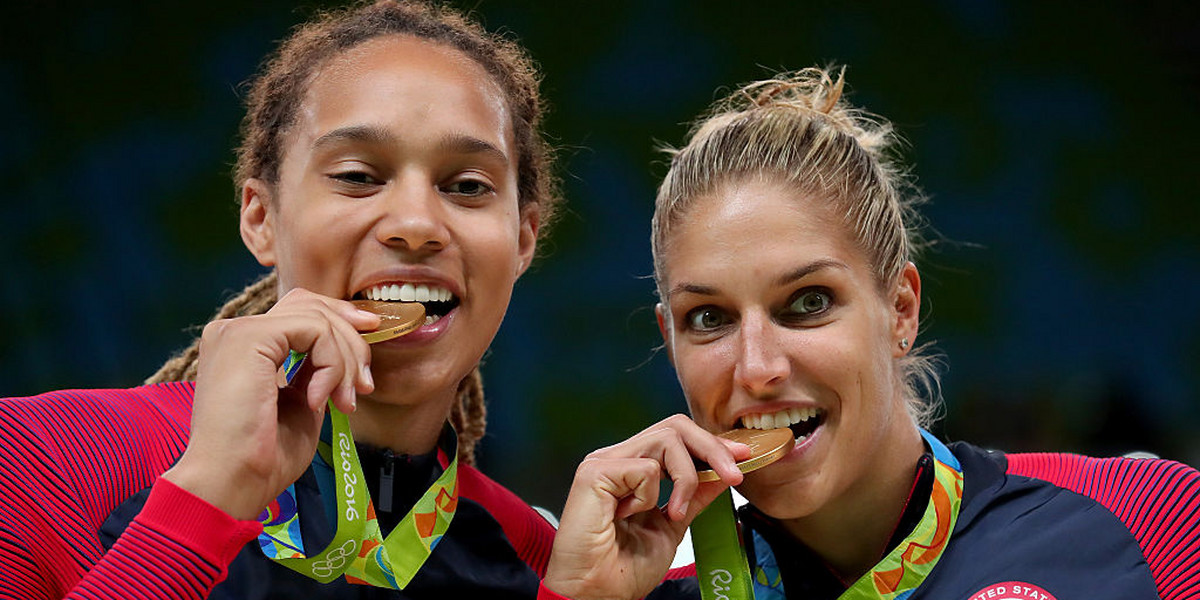 Brittney Griner (left) and Elena Delle Donne bite the gold medals they won in Rio.