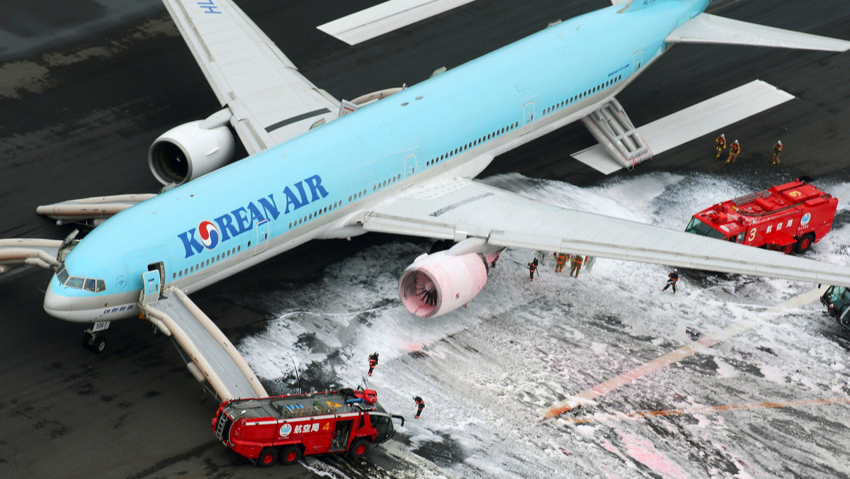 An aerial picture shows firefighters spraying foam at the engine of a Korean Air Lines plane after smoke rose from it at Haneda airport in Tokyo