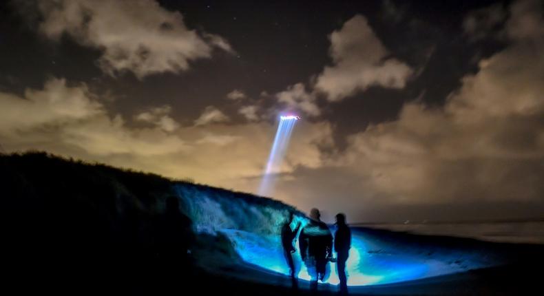 French gendarmes patrol while a police helicopter flies over the beach of Oye-Plage, near Calais, northern France, as they try to intercept migrants attempting to cross the Channel