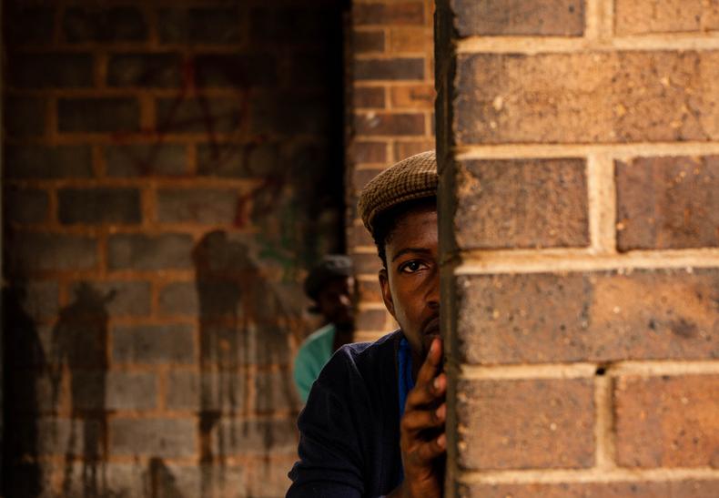 Man hiding behind a wall