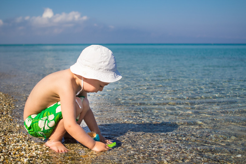 Chłopiec bawi się w piasku na plaży